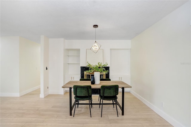 dining space featuring light wood-type flooring and baseboards