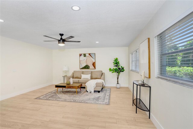 interior space with a textured ceiling, light wood-type flooring, and ceiling fan