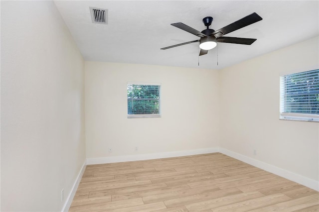 spare room featuring baseboards, visible vents, and light wood finished floors