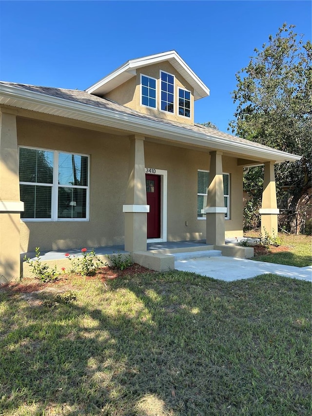 view of front of home with a porch and a front yard