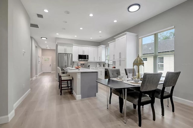 dining space with sink and light hardwood / wood-style floors