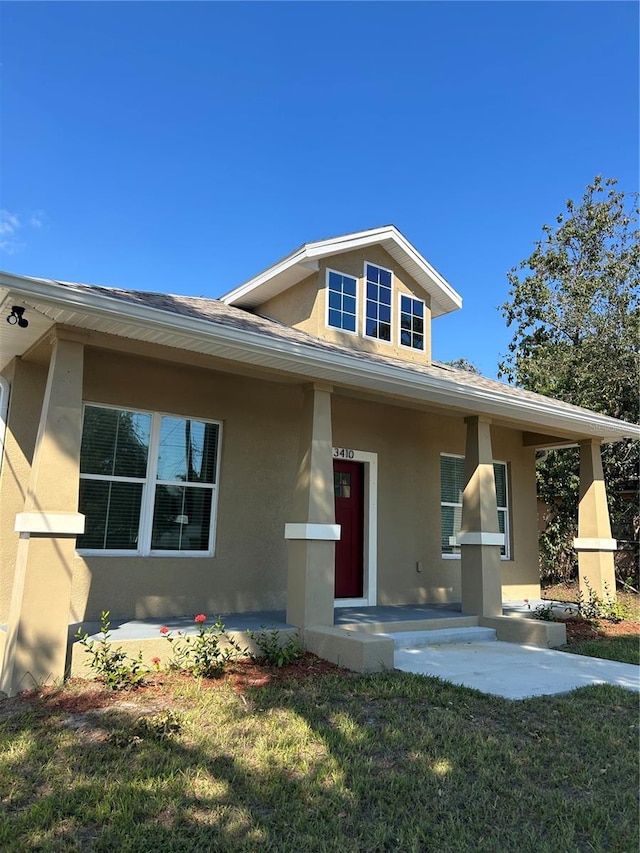 view of front of home featuring covered porch and a front yard