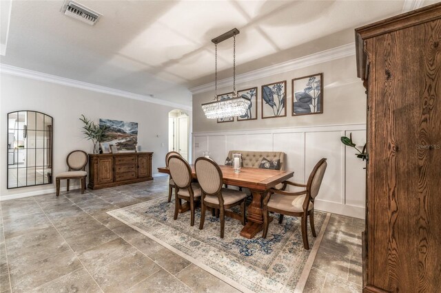 dining space featuring a notable chandelier, ornamental molding, and tile patterned flooring