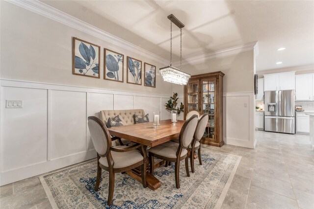 tiled dining area featuring an inviting chandelier and crown molding