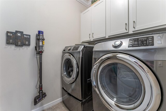 washroom featuring cabinets, light tile patterned floors, and washer and dryer