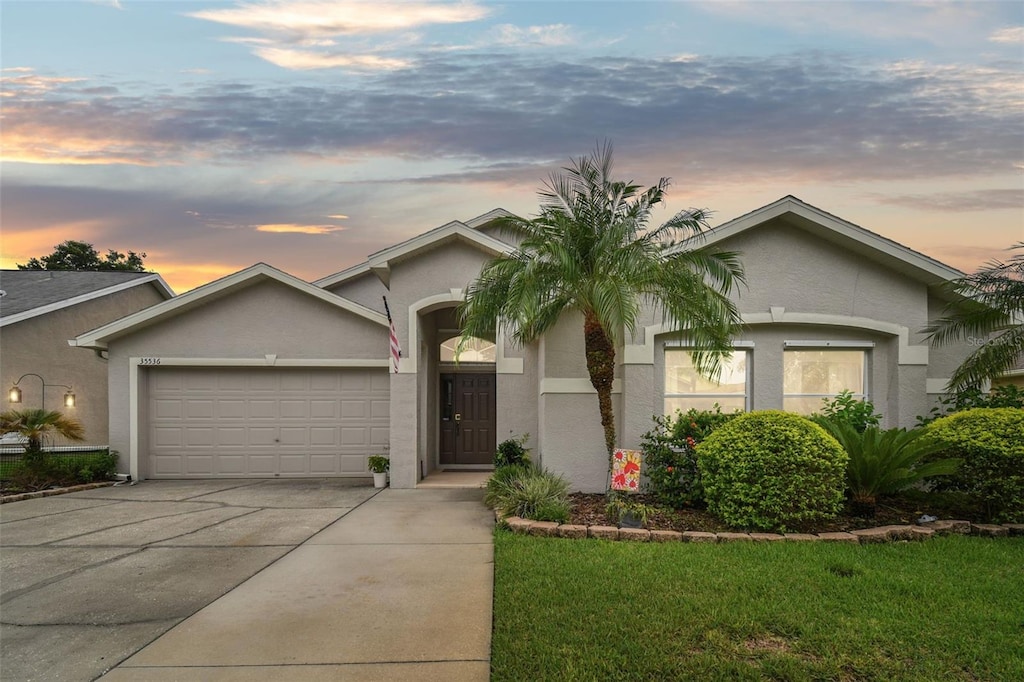 ranch-style house featuring a lawn and a garage