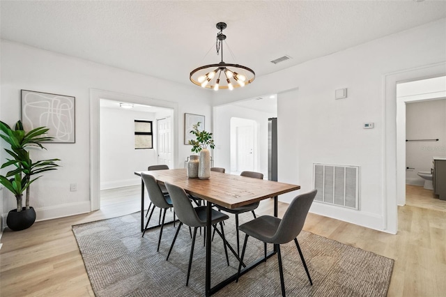 dining room featuring a notable chandelier and light wood-type flooring