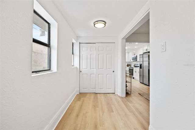 hallway featuring light hardwood / wood-style flooring and plenty of natural light