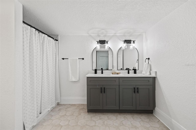 bathroom with a textured ceiling, vanity, and tile patterned flooring