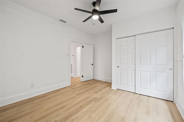 unfurnished bedroom featuring ceiling fan, light hardwood / wood-style flooring, and a closet