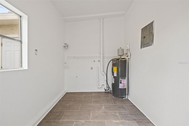 laundry area with electric water heater, electric panel, and tile patterned flooring