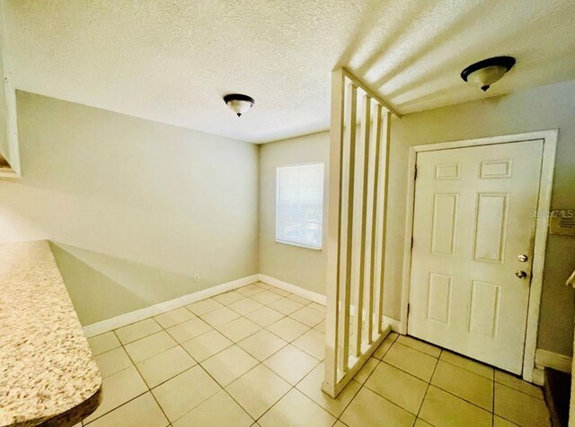 foyer featuring a textured ceiling and light tile patterned floors