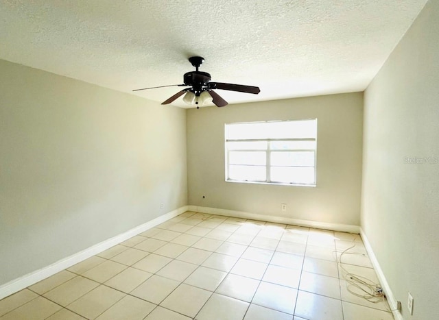 spare room featuring ceiling fan, a textured ceiling, and light tile patterned floors