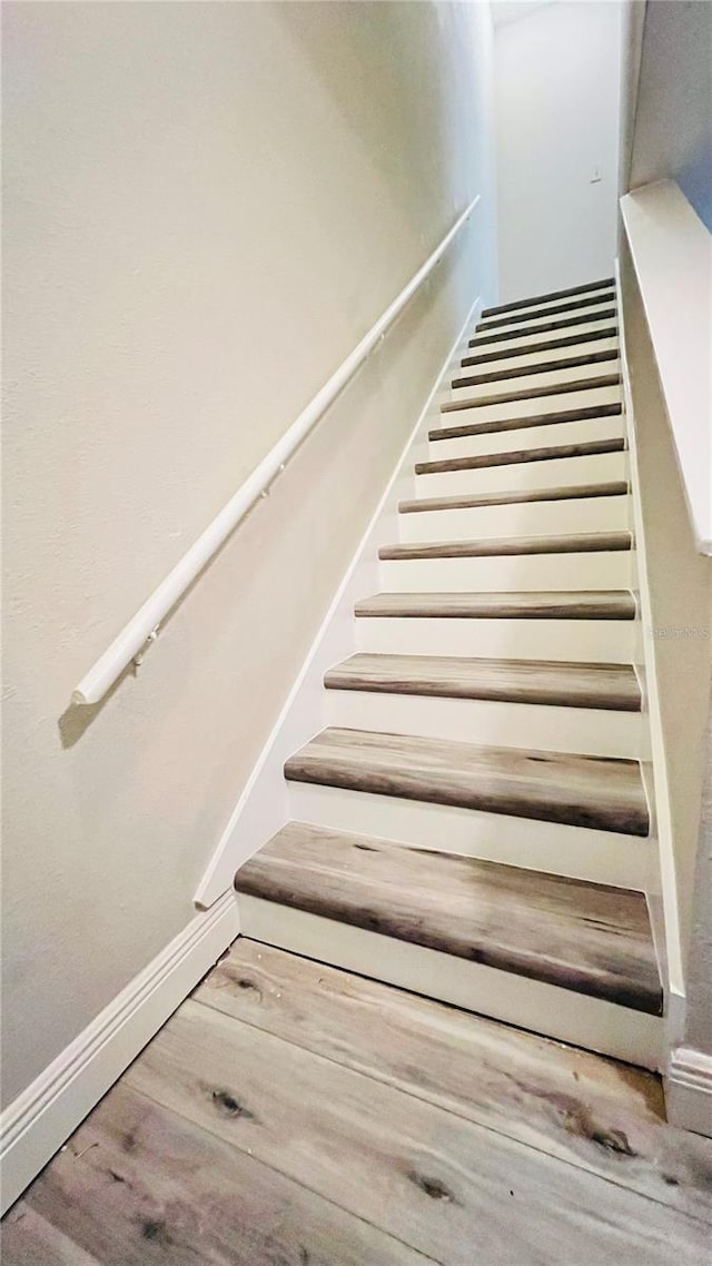 staircase with hardwood / wood-style floors