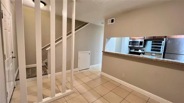 interior space with tile patterned flooring and a textured ceiling