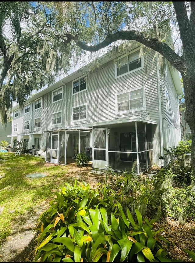 rear view of house featuring a sunroom