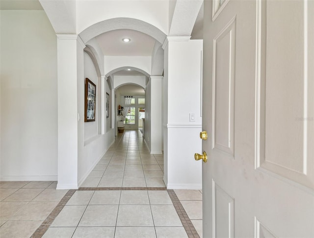 corridor featuring recessed lighting, baseboards, and light tile patterned floors