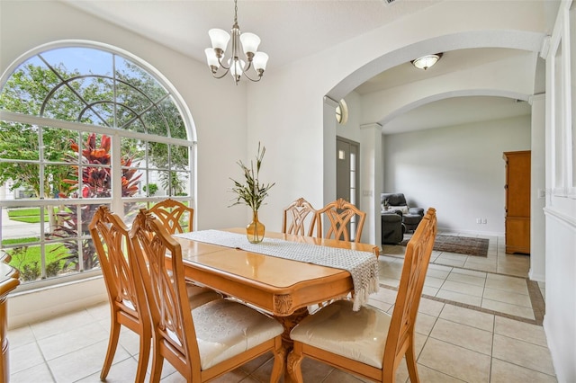 dining space featuring light tile patterned flooring and an inviting chandelier