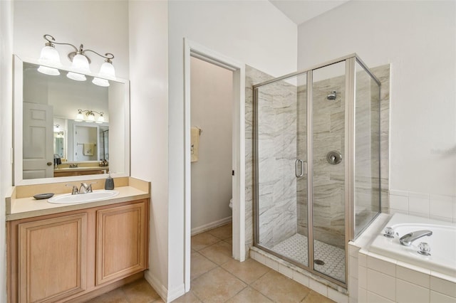 bathroom with tile patterned floors, vanity, and shower with separate bathtub