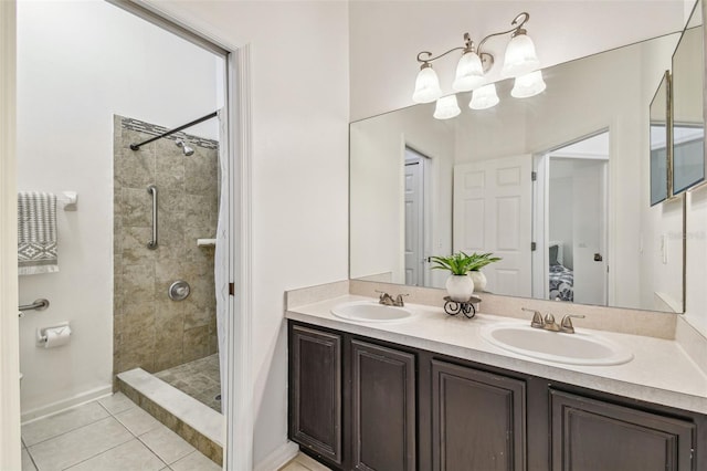 bathroom with tile patterned flooring, a tile shower, and vanity