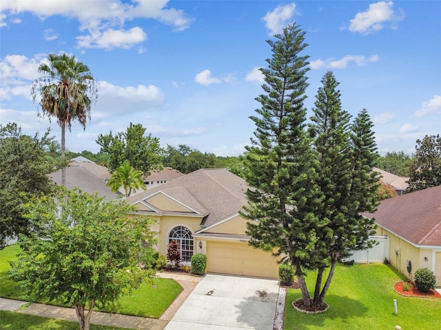 view of property hidden behind natural elements with a front yard and a garage