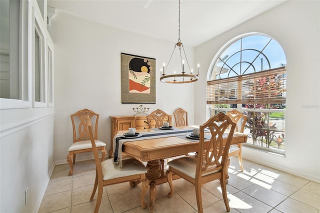 dining space featuring light tile patterned floors, baseboards, and an inviting chandelier