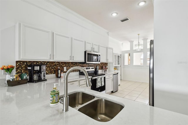 kitchen with light tile patterned floors, stainless steel appliances, decorative backsplash, ornamental molding, and a sink