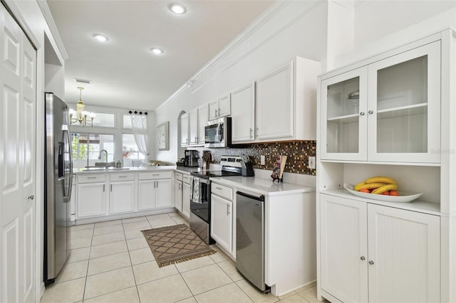 kitchen featuring light tile patterned floors, a sink, light countertops, appliances with stainless steel finishes, and backsplash