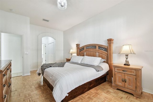 bedroom featuring arched walkways, a closet, visible vents, and baseboards