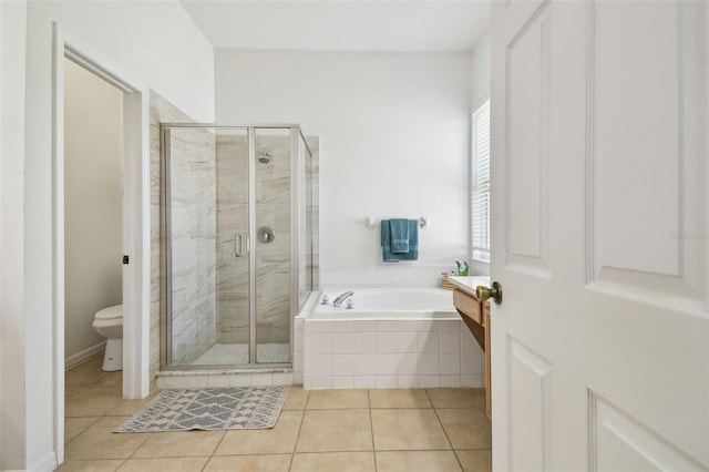 full bathroom featuring toilet, a garden tub, a shower stall, and tile patterned floors