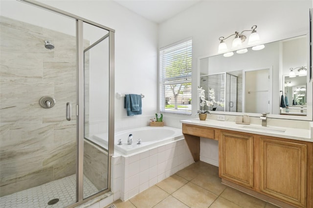 bathroom featuring a stall shower, tile patterned flooring, a bath, and vanity