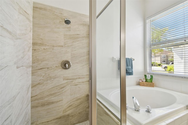 bathroom with a bath and tiled shower