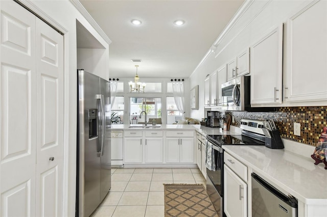 kitchen with tasteful backsplash, light tile patterned floors, a notable chandelier, a sink, and stainless steel appliances