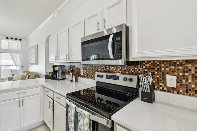 kitchen with light countertops, tasteful backsplash, crown molding, and stainless steel appliances