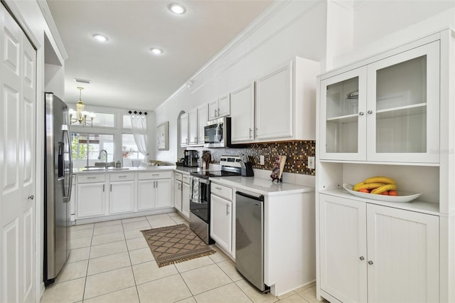 kitchen with a notable chandelier, light countertops, stainless steel appliances, backsplash, and light tile patterned flooring