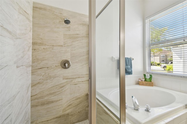 full bathroom with a bath and a tile shower