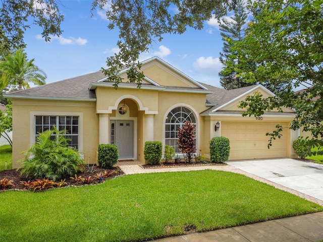 view of front of property with a front yard, a shingled roof, an attached garage, stucco siding, and driveway