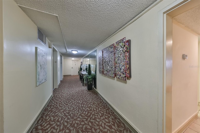 hall with a textured ceiling and carpet