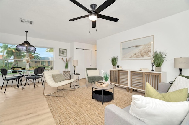 living room with ceiling fan and light hardwood / wood-style floors