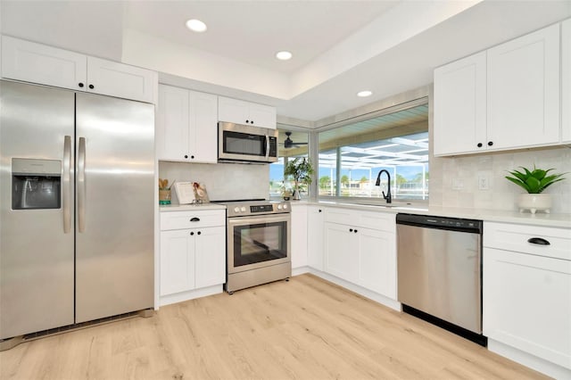 kitchen with white cabinetry, sink, decorative backsplash, and appliances with stainless steel finishes