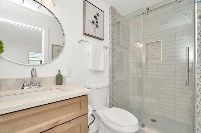 bathroom with vanity, toilet, and an enclosed shower