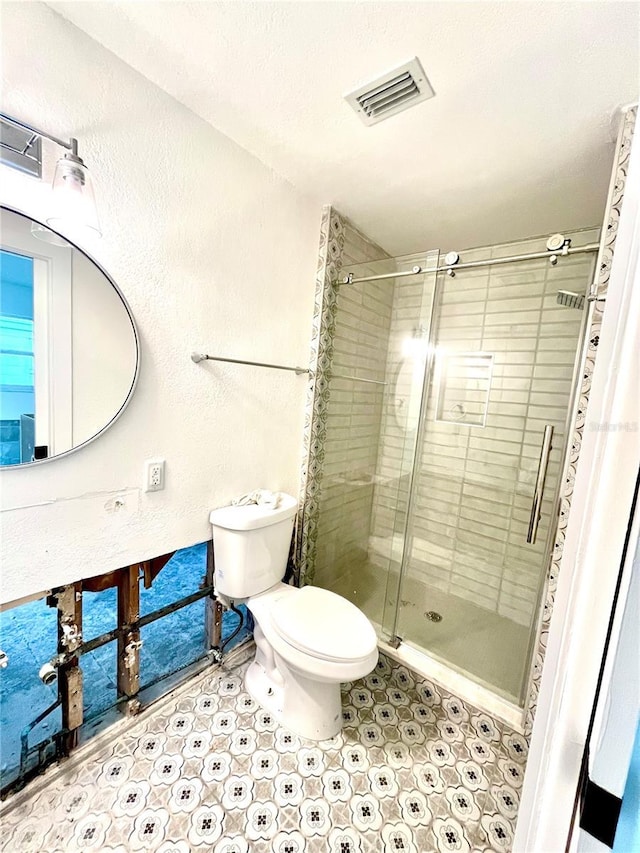 bathroom featuring toilet and an enclosed shower