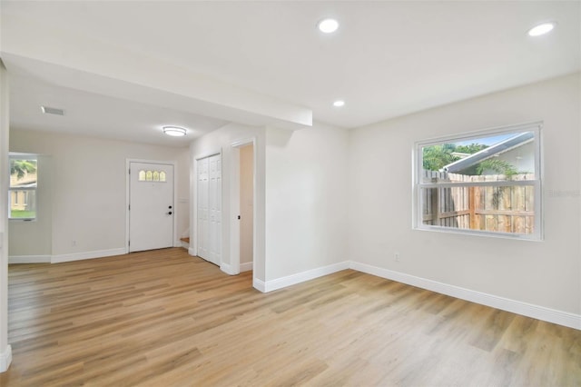 empty room featuring baseboards, light wood-type flooring, visible vents, and recessed lighting