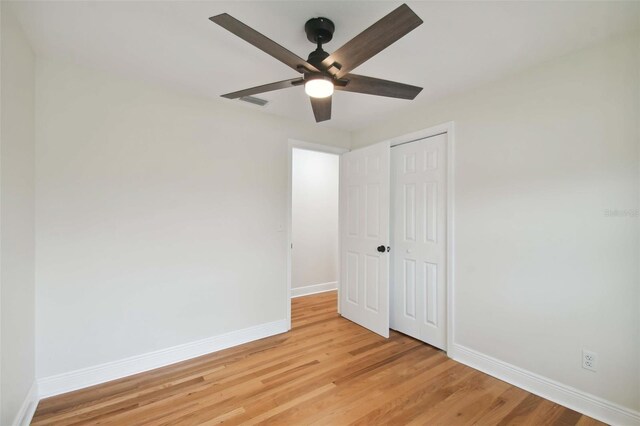 unfurnished bedroom featuring a closet, ceiling fan, and light wood-type flooring