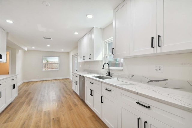 kitchen featuring light stone counters, sink, light hardwood / wood-style flooring, and white cabinets