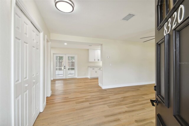 foyer entrance with light hardwood / wood-style floors and french doors