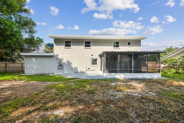 back of house featuring a sunroom, fence, and a patio