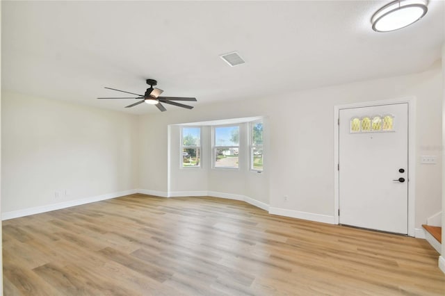 interior space featuring ceiling fan, light wood-type flooring, visible vents, and baseboards