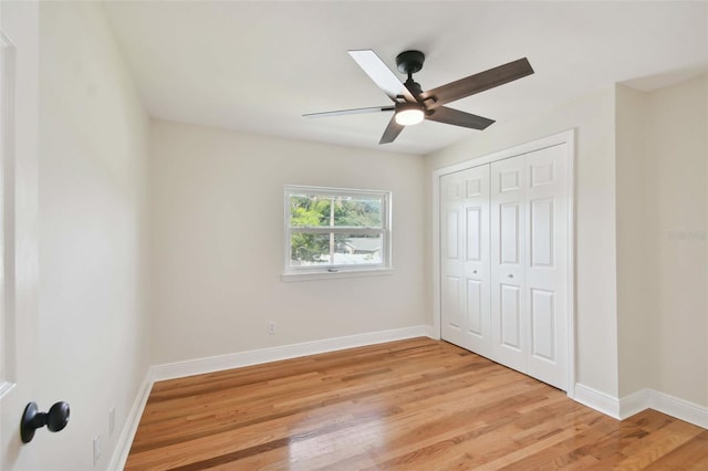 unfurnished bedroom with ceiling fan, a closet, light wood-type flooring, and baseboards