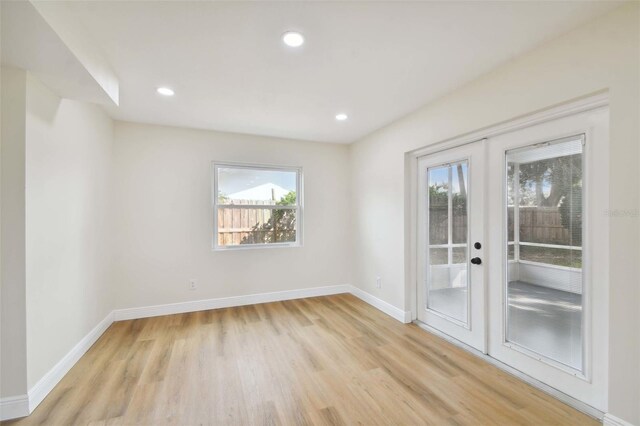 unfurnished room with light hardwood / wood-style floors and french doors